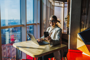 A modern professional excels in a stylish office with a city view, enjoying remote work benefits. They use advanced technology to boost productivity and motivation for an efficient, enjoyable day