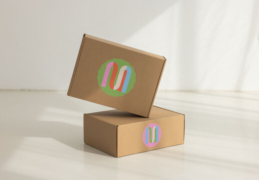 Two cardboard boxes stacked on a light surface with shadows. front and side