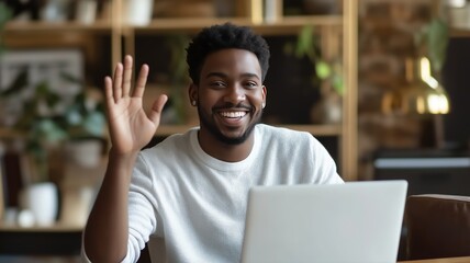 Obraz premium Smiling person waves hello while working on a laptop in a cozy indoor workspace