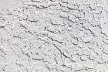 The wall is covered in cracks and has a rough texture