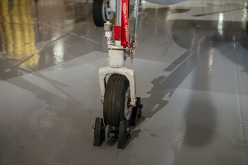 Close-up view of the front landing gear wheel of a military jet secured with chocks. The aircraft...