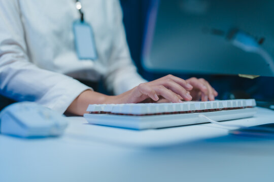 Office worker typing on keyboard in modern office at night