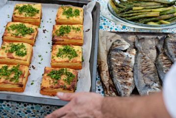 Grilled fish with vegetables. Gratin made from potatoes and asparagus ready to eat. Chef preparing main dinner on plate. Healthy food from grill as a delicious meal. Close up.