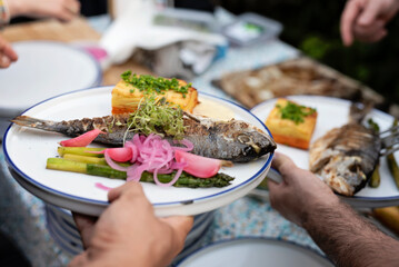 Healthy grilled fish with salad and vegetables on a plate. Preparation a meal for lunch or dinner on barbeque. Cooking delicious food on garden party. or restaurant. Close up.