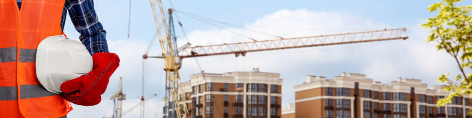 Builder in safety equipment at construction site, closeup. Banner design