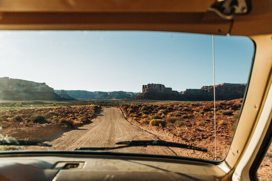 Vintage vehicle windshield view of dirt road in Valley of the Gods