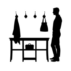 Silhouette of man by console table with hooks on white background, interior simplicity