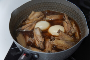 鶏手羽中の煮物を作る様子