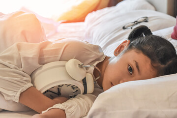 Sleep disorder in sleepless girl child suffering insomnia problem, mental health illness. Young asian school kid, keeping awake with anxiety or nightmare fear on bed at late night in home bedroom