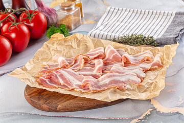 Sliced pork bacon over board