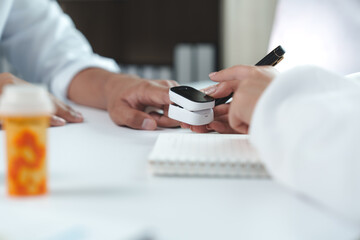 Fototapeta premium Doctor measuring patient blood oxygen saturation with pulse oximeter