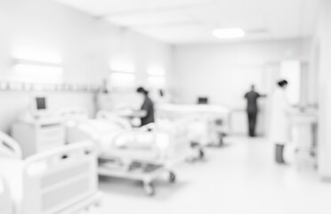 Blurred hospital room with medical staff and beds in a bright white setting.