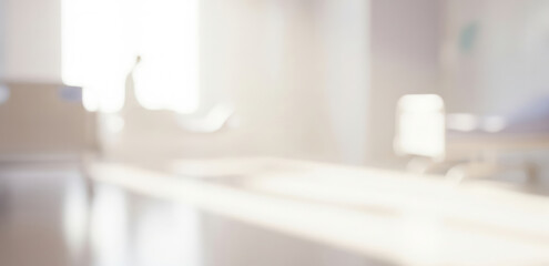 Blurry interior scene with a desk and window light.