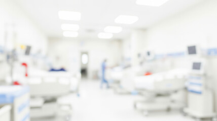 Blurred hospital room with beds and medical equipment in a bright setting.