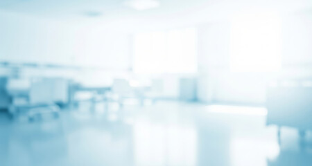 Blurred interior view of a bright hospital room with furniture and equipment.