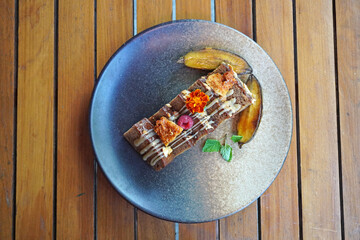 Banana cake decorating with fresh cream, fruit, cookies and edible flowers 