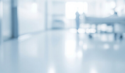 Blurred hospital interior with a bed and equipment in a bright environment.