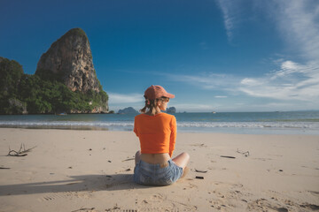 happy woman sit down on the beach at krabi province, Thailand. soft focus