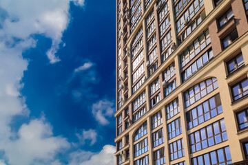 City view on a sunny day. Modern building and houses against the blue sky.