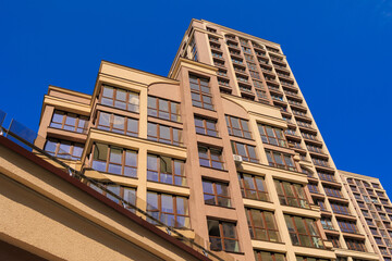 City view on a sunny day. Modern building and houses against the blue sky.