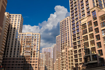 City view on a sunny day. Modern building and houses against the blue sky.