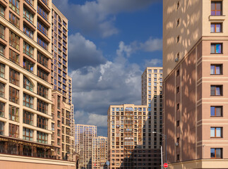 City view on a sunny day. Modern building and houses against the blue sky.