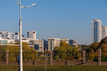City view on a sunny day. Modern building and houses against the blue sky.