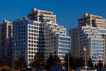 City view on a sunny day. Modern building and houses against the blue sky.