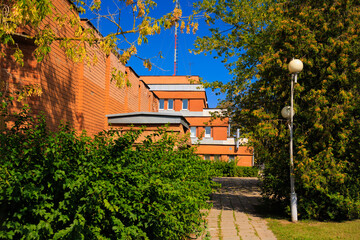 Cityscape on a summer day, modern buildings and houses against the blue sky 