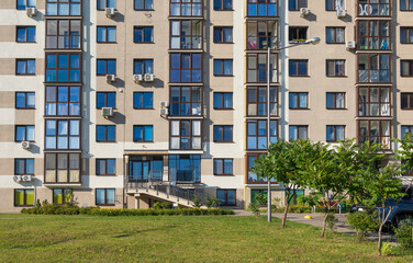 Cityscape on a summer day, modern buildings and houses against the blue sky 