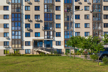 City view on a sunny day. Modern building and houses against the blue sky.