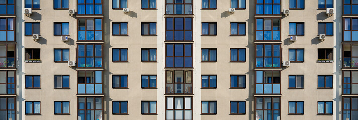 Fototapeta premium City view on a sunny day. Modern building and houses against the blue sky.