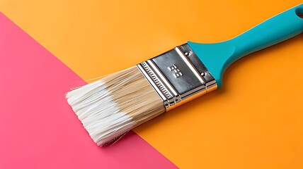 Bright teal paintbrush on pink and orange background