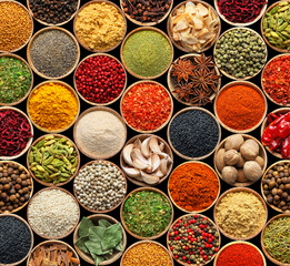 Set of different aromatic spices in bowls on black background, flat lay