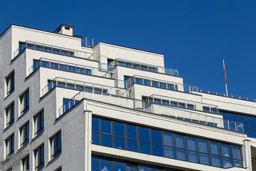 City view on a sunny day. Modern building and houses against the blue sky.