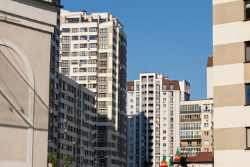 City view on a sunny day. Modern building and houses against the blue sky.