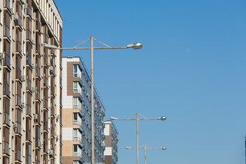 City view on a sunny day. Modern building and houses against the blue sky.