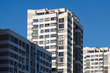 City view on a sunny day. Modern building and houses against the blue sky.