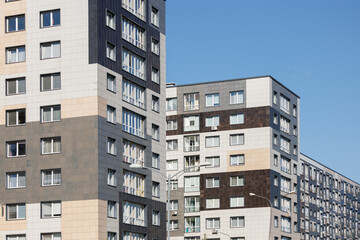 City view on a sunny day. Modern building and houses against the blue sky.