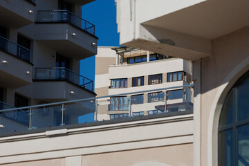 City view on a sunny day. Modern building and houses against the blue sky.