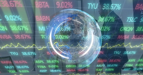 Traders wearing suits manipulating holographic globe and tickers in trading office with laptops
