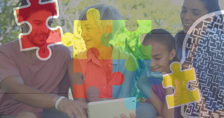 Watching extended family viewing tablet on garden bench, with floating colorful puzzle graphics