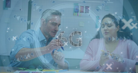 Colleagues gesturing toward charts and checking smartphone in office meeting room, with 6G overlay