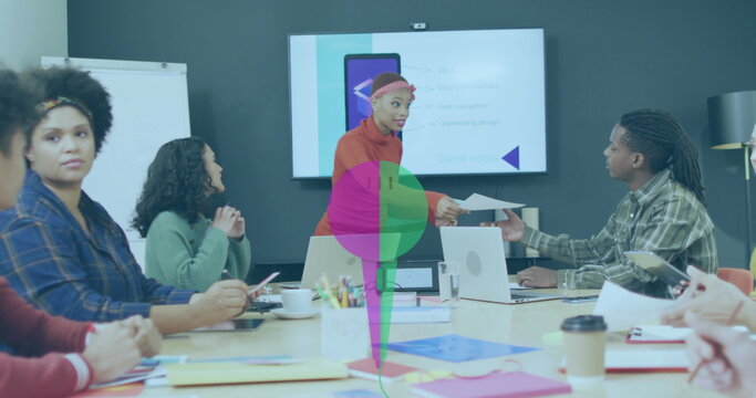 Handing document mid adult woman wearing orange sweater at meeting table, with laptops notebooks - Powered by Adobe