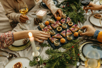 Family enjoying christmas appetizers and wine at festive table setting