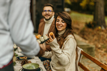 Woman choosing delicious appetizer at outdoor autumn restaurant table