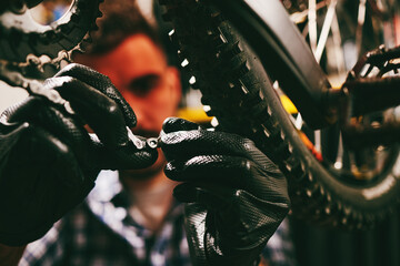 Bicycle mechanic repairing bike chain in workshop