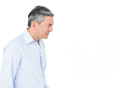 Man standing wearing light blue shirt in studio showing tense focus facing right, copy space