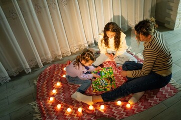 Enjoying a cozy evening with loved ones while playing a board game surrounded by soft candlelight...