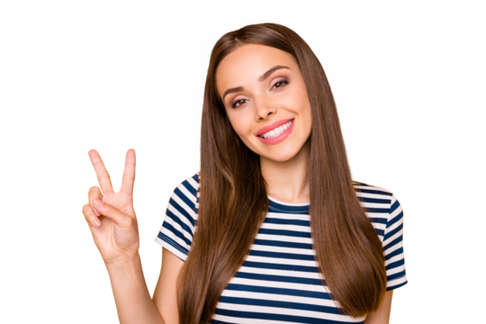 Close up photo of sweet lady making v-signs looking at camera smiling wearing striped t-shirt isolated over yellow background